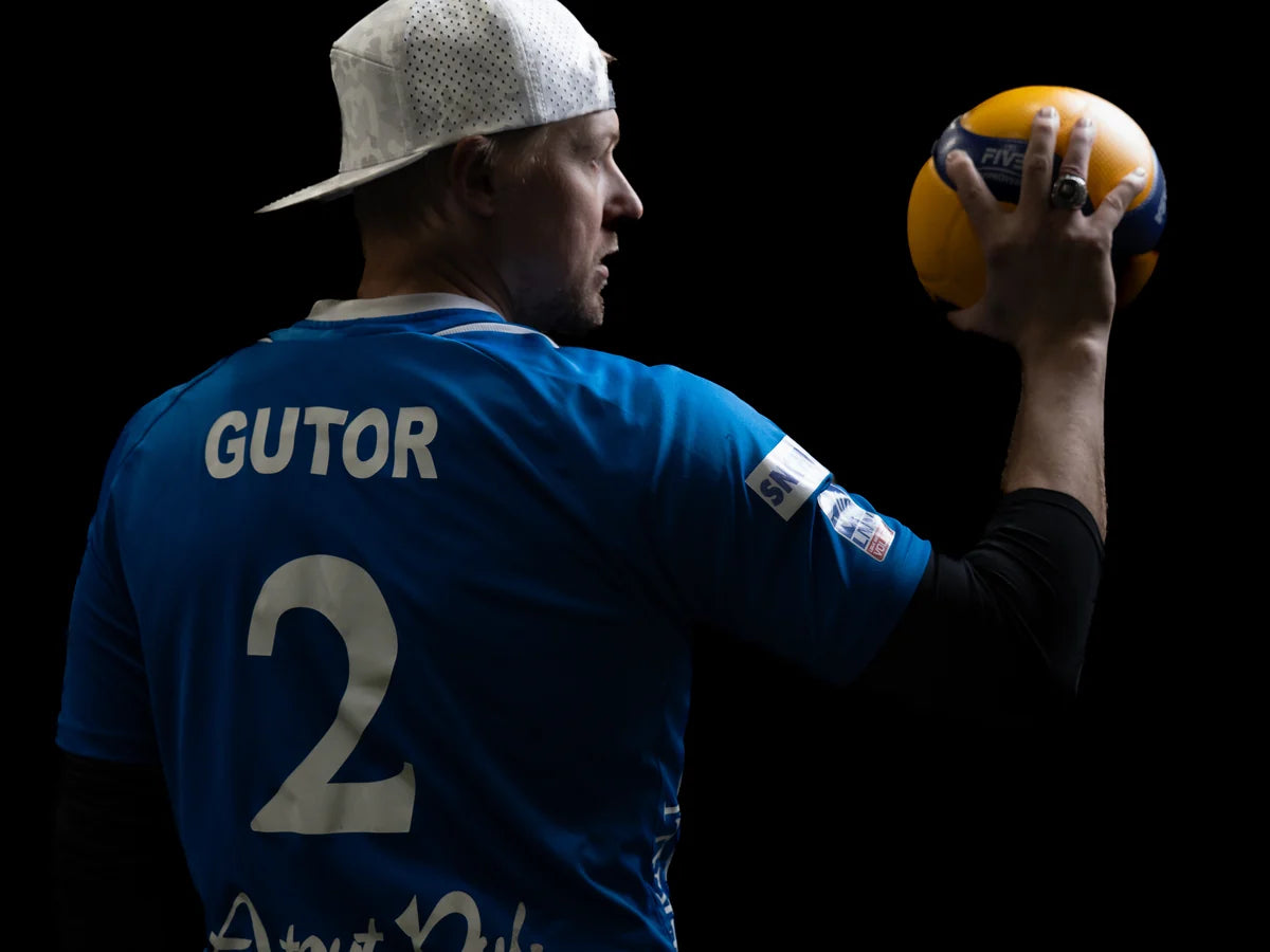 Coach Gutor holding a volleyball.